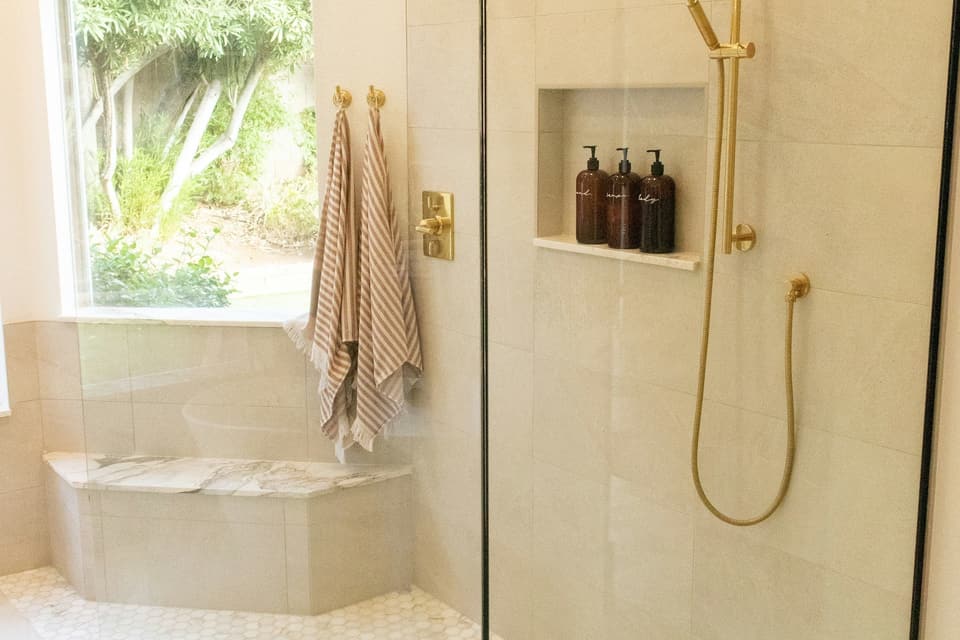 Douche à l'italienne avec paroi vitrée, caniveau et robinetterie en laiton
