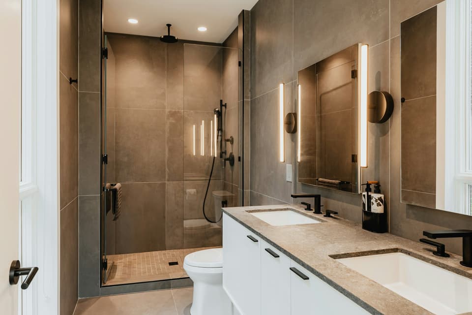 Salle de bain contemporaine : douche à l'italienne en pierre, robinetterie noire et double vasque