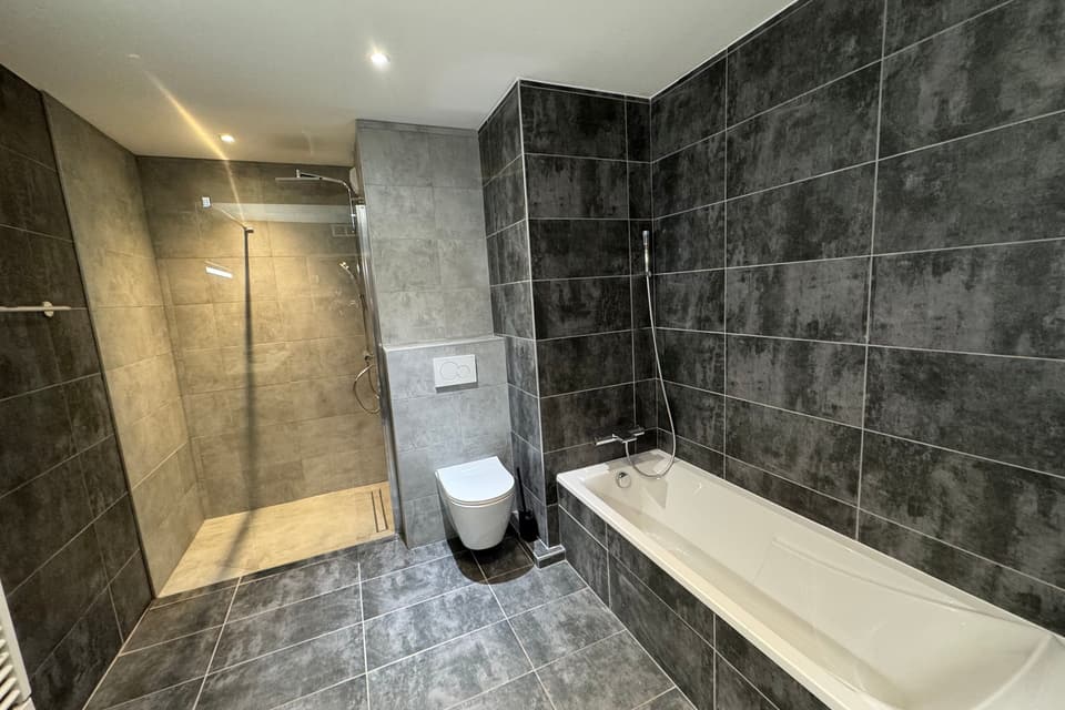 Salle de bain rénovée avec douche à l'italienne, baignoire et WC suspendu, réalisée par KAT Plomberie, plombier à Anthy-sur-Léman